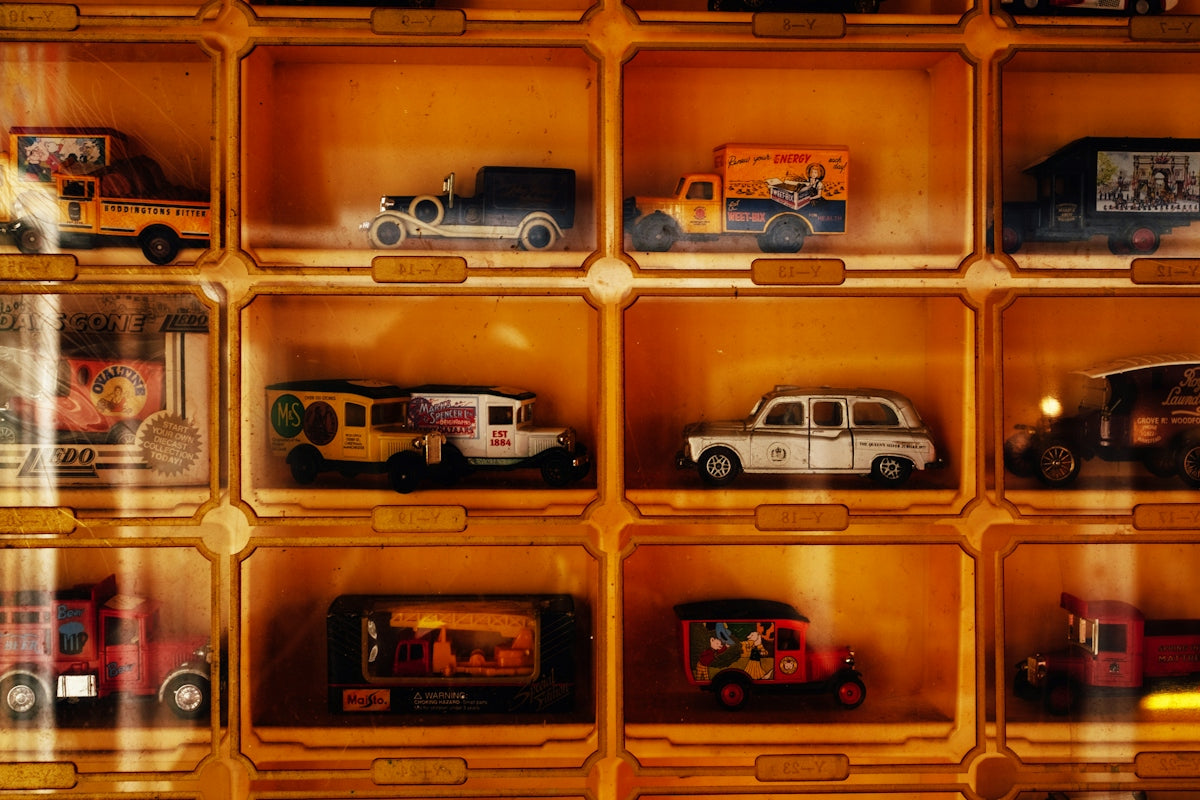 Collection of vintage toy cars displayed in wooden cubbies
